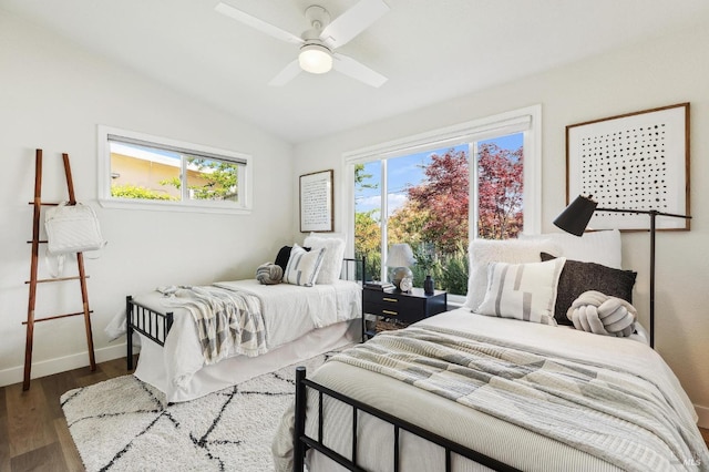 bedroom featuring a ceiling fan, baseboards, vaulted ceiling, and wood finished floors