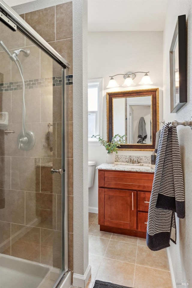 full bath with vanity, tile patterned floors, baseboards, and a stall shower