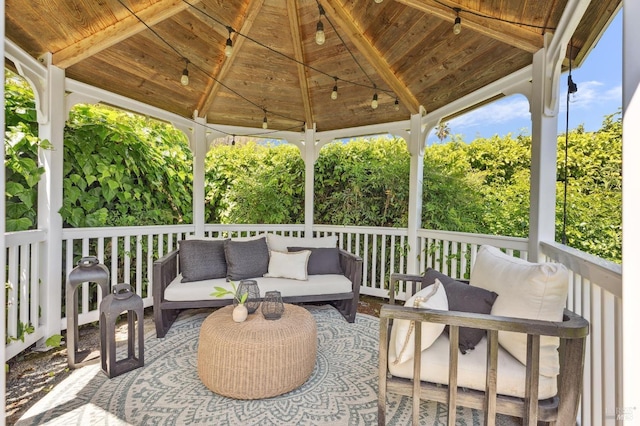 wooden terrace featuring a gazebo and an outdoor living space