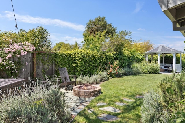 view of yard featuring a gazebo, an outdoor fire pit, and fence