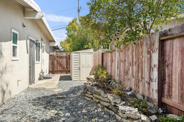 view of yard with a fenced backyard, a storage unit, and an outdoor structure