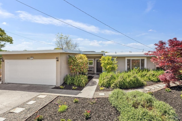 ranch-style home with a garage, stucco siding, and driveway