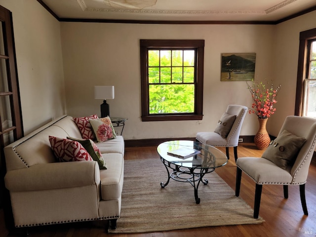 living area featuring crown molding, baseboards, plenty of natural light, and wood finished floors