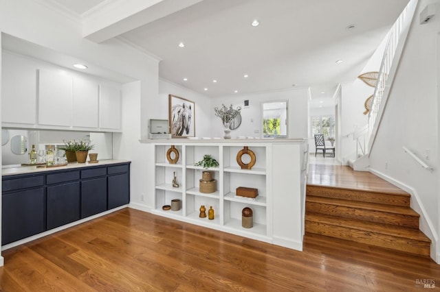 kitchen featuring ornamental molding, wood finished floors, recessed lighting, light countertops, and white cabinets