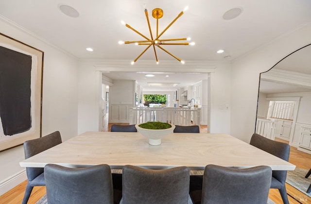 dining space with recessed lighting, a chandelier, ornamental molding, and light wood-style floors