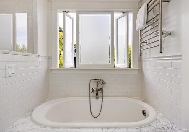 full bathroom with radiator heating unit, tile walls, and a bath