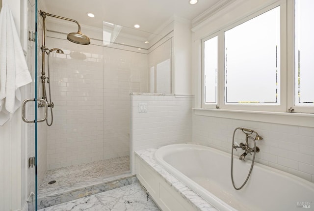 bathroom with marble finish floor, ornamental molding, a garden tub, and a stall shower