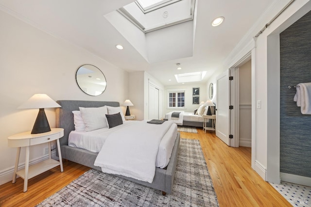 bedroom featuring recessed lighting, a skylight, baseboards, and light wood finished floors