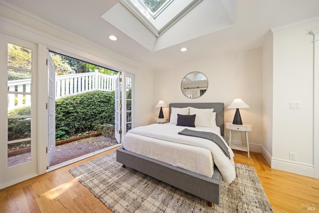 bedroom with access to outside, light wood-style flooring, recessed lighting, a skylight, and ornamental molding