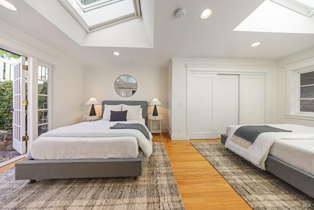 bedroom featuring light wood-style floors, recessed lighting, baseboards, and a skylight