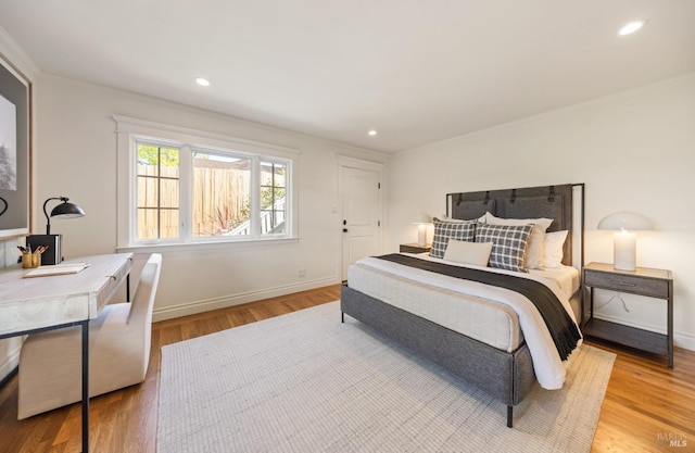 bedroom with recessed lighting, baseboards, ornamental molding, and wood finished floors