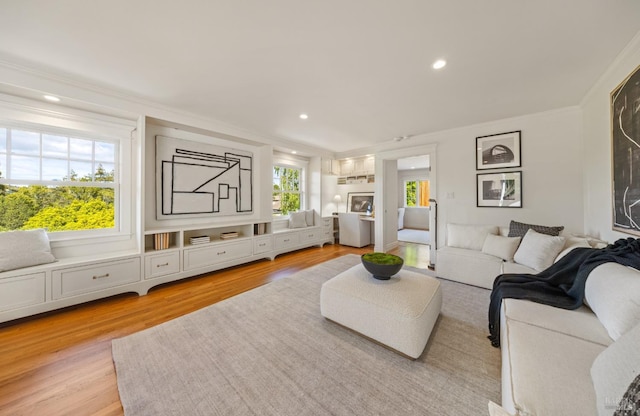 living area with recessed lighting, ornamental molding, and light wood-style flooring