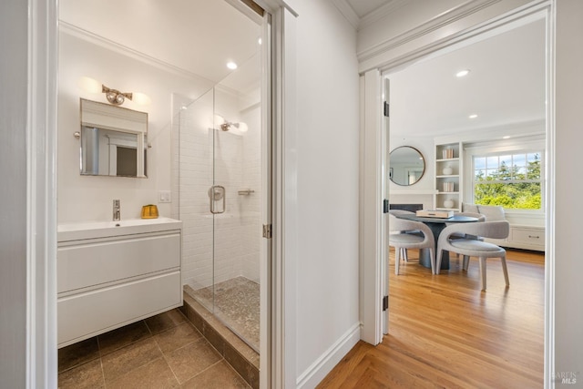 bathroom featuring crown molding, a shower stall, vanity, baseboards, and recessed lighting