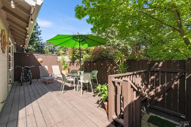 wooden deck featuring outdoor dining area and a fenced backyard