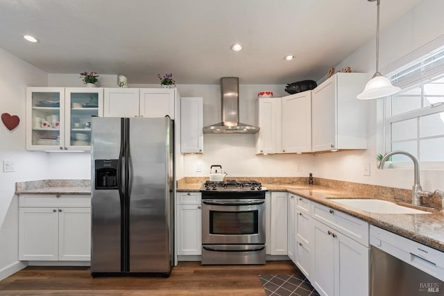 kitchen featuring a sink, appliances with stainless steel finishes, dark wood-style floors, and wall chimney exhaust hood