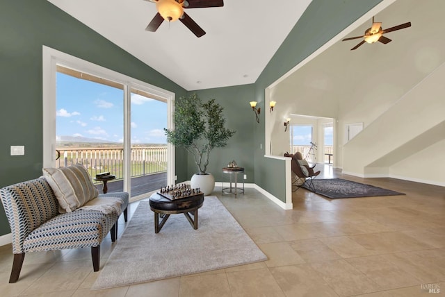 living area with tile patterned floors, baseboards, a ceiling fan, and high vaulted ceiling