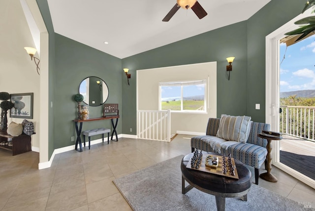 living area with a ceiling fan, tile patterned floors, vaulted ceiling, and an upstairs landing