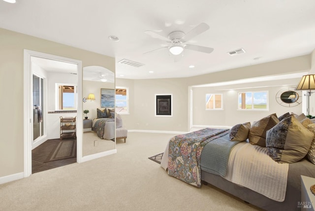 carpeted bedroom with baseboards, a ceiling fan, and visible vents