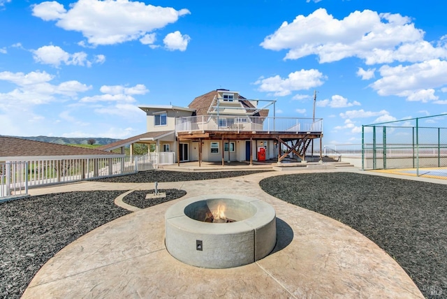 rear view of house featuring fence, an outdoor fire pit, a wooden deck, stairway, and a patio