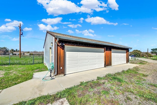 detached garage featuring fence
