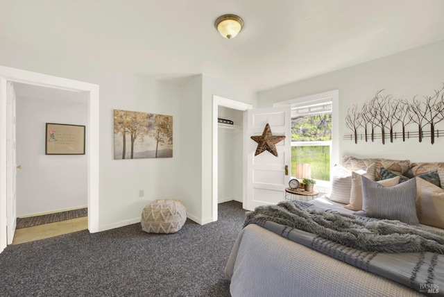 carpeted bedroom featuring baseboards and a closet