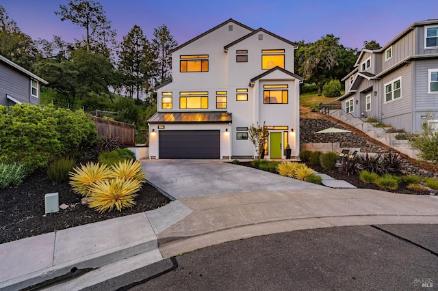 view of front of house with stairway, a garage, driveway, and stucco siding