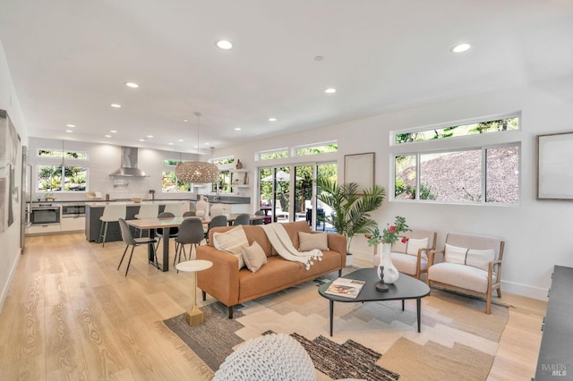 living area featuring recessed lighting, baseboards, and light wood-type flooring