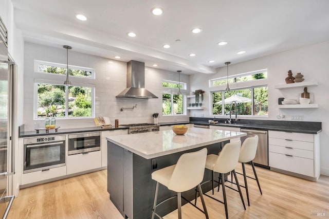 kitchen featuring wall chimney range hood, modern cabinets, open shelves, and stainless steel appliances