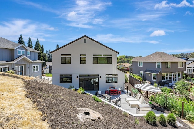 back of property featuring fence, a patio, stucco siding, and a residential view