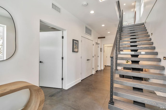 staircase with visible vents, recessed lighting, and finished concrete flooring