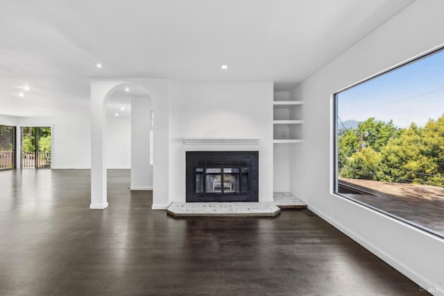 unfurnished living room with baseboards, recessed lighting, and wood finished floors