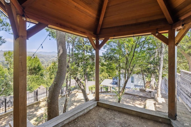 exterior space featuring a fenced backyard, a mountain view, and a sunroom
