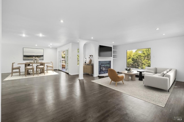 living room with baseboards, recessed lighting, a tile fireplace, and dark wood-type flooring