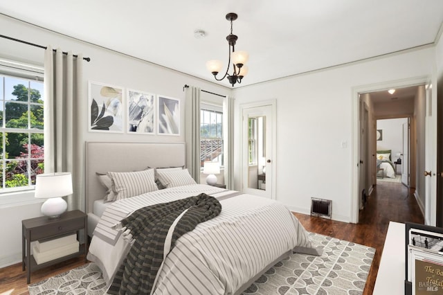 bedroom with baseboards, visible vents, and wood finished floors