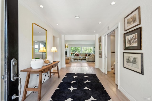 corridor featuring crown molding, baseboards, light wood-style floors, and recessed lighting