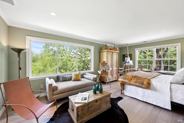 bedroom featuring crown molding, multiple windows, and wood finished floors