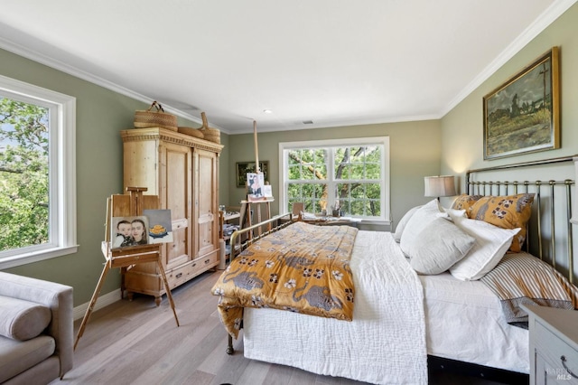 bedroom with baseboards, multiple windows, and light wood-style flooring