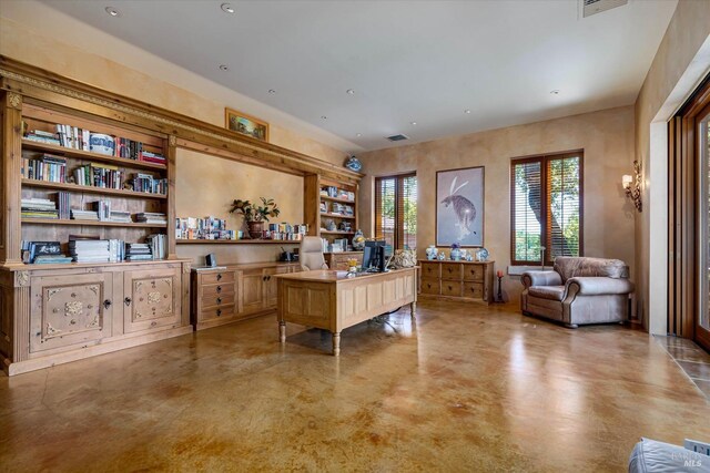 home office featuring visible vents, recessed lighting, concrete floors, and built in shelves