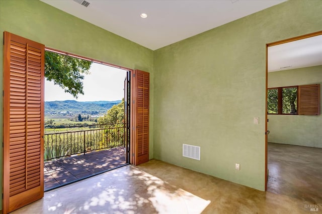 exterior space featuring visible vents, finished concrete flooring, and a mountain view