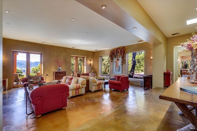 living area featuring visible vents, recessed lighting, concrete flooring, and a healthy amount of sunlight