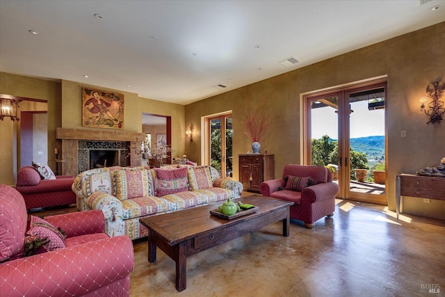 living room with concrete flooring, visible vents, and a fireplace