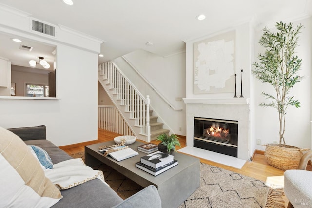 living room featuring visible vents, wood finished floors, stairway, recessed lighting, and a premium fireplace