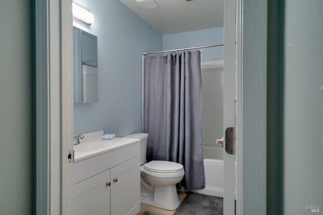 bathroom featuring vanity, shower / bath combination with curtain, and toilet