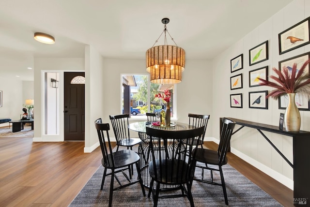 dining room with an inviting chandelier, baseboards, and wood finished floors