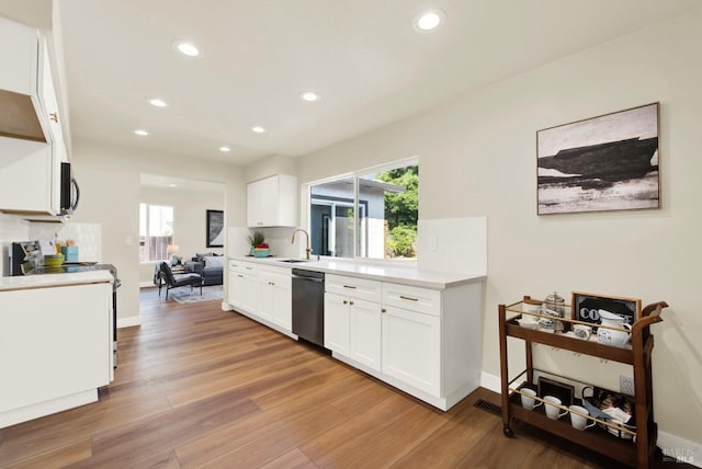 kitchen featuring stainless steel appliances, recessed lighting, light countertops, white cabinets, and light wood-style floors