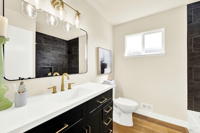 bathroom featuring toilet, baseboards, visible vents, wood finished floors, and a shower