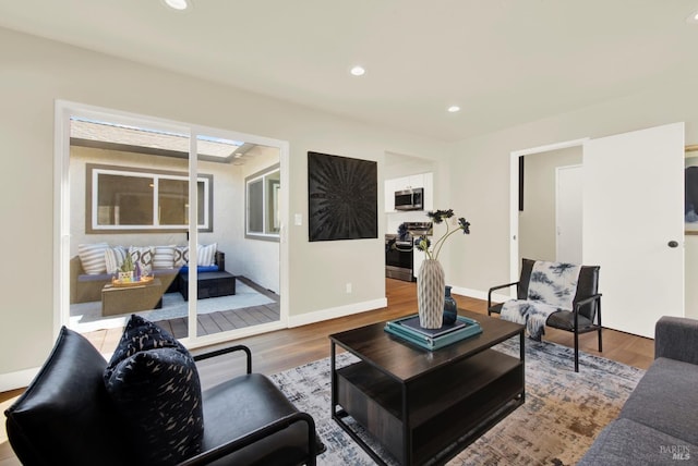 living room featuring wood finished floors, baseboards, and recessed lighting