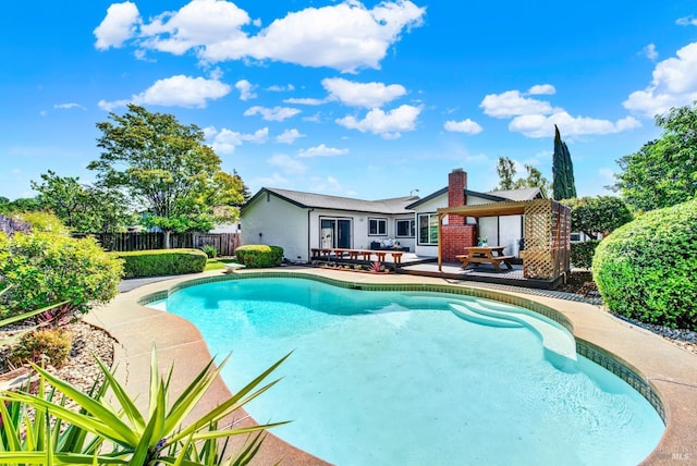 view of pool featuring fence, a patio, a fenced in pool, and a diving board