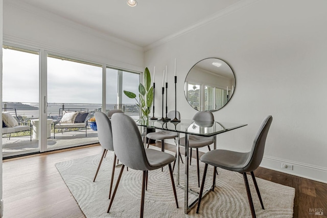 dining room with crown molding, baseboards, and wood finished floors
