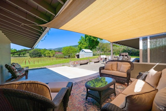 view of patio / terrace with an outdoor structure, a mountain view, and an outdoor hangout area